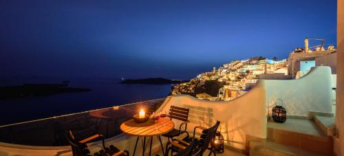 a balcony with a table with a candle on it at Aethria Villa in Imerovigli