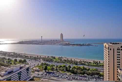 a view of a beach with a city and the ocean at SPACIOUS 3 Bedroom Apartment (Sea View) in Abu Dhabi