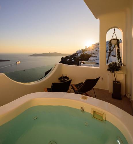 a bath tub in a room with a view of the ocean at Aethria Villa in Imerovigli