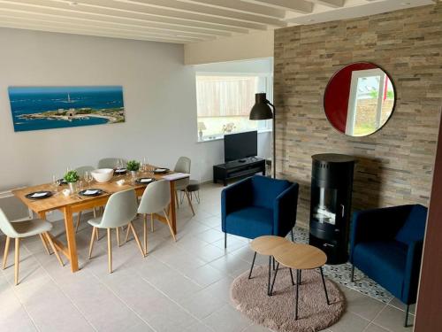 a dining room with a table and a fireplace at Maison Bord de Mer dans la Petite Irlande in Auderville