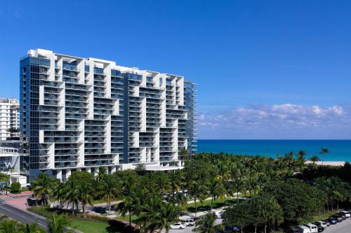 een hoog gebouw met palmbomen voor de oceaan bij W South Beach in Miami Beach