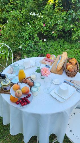 a white table with plates of food on it at Chambre d'hôtes à la campagne Nevers in Challuy