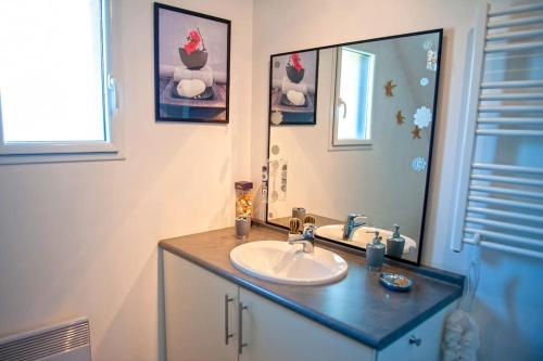 bagno con lavandino e specchio di Maison familiale-COSY a Sainte-Anne-d'Auray