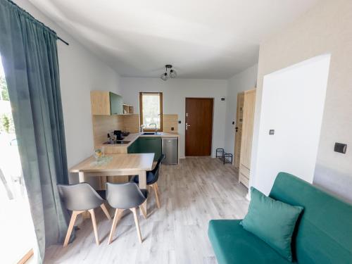 a kitchen and living room with a table and chairs at PRZYSTANEK G&S in Nickelswalde