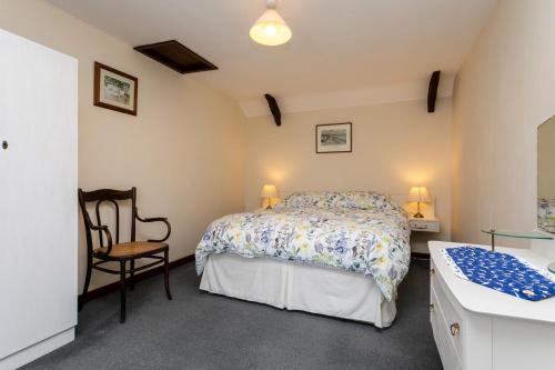 a bedroom with a bed and a desk and a chair at Swallows Cottage nr Warkworth in Acklington