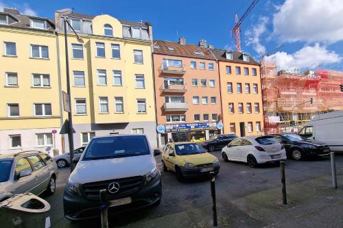 ein Parkplatz mit Autos vor den Gebäuden in der Unterkunft cozy Apartments in Mülheim in Köln