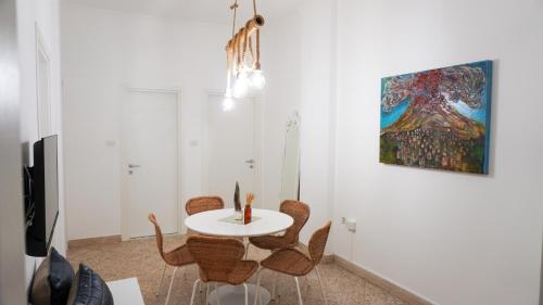 un comedor con mesa, sillas y una pintura en Donna Elena House, en Maiori