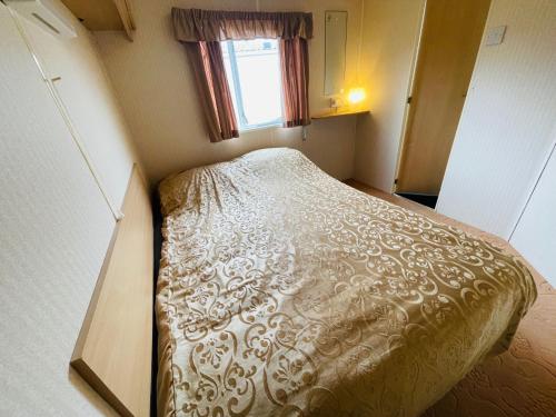 een kleine slaapkamer met een bed in een kleine kamer bij Holiday Caravan Holle Poarte Makkum in Makkum
