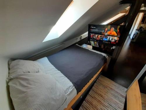 a small bed in a room with a tv at Reload Apartment in Miskolc