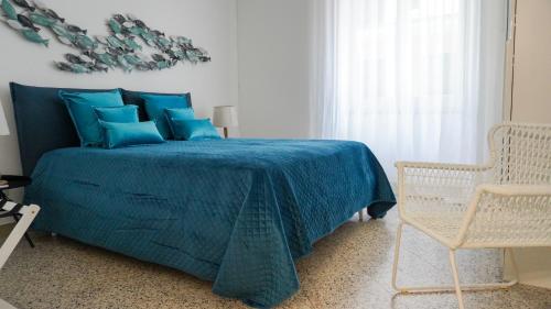 a bedroom with a blue bed and a chair at Donna Elena House in Maiori