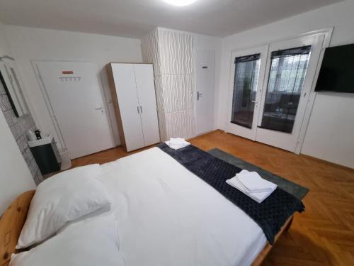 a bedroom with a large white bed and two windows at Pension DonauBlick Grein 1 , Spitzfeldstr 1 in Grein
