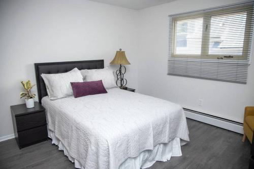 a bedroom with a white bed and a window at Tranquil Retreats on Robinson in Moncton