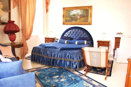 1 dormitorio con 1 cama azul y 1 silla en Charme Holidays Colosseum, en Roma