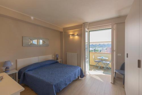 a bedroom with a blue bed and a balcony at Casa Anna by HelloElba in Portoferraio