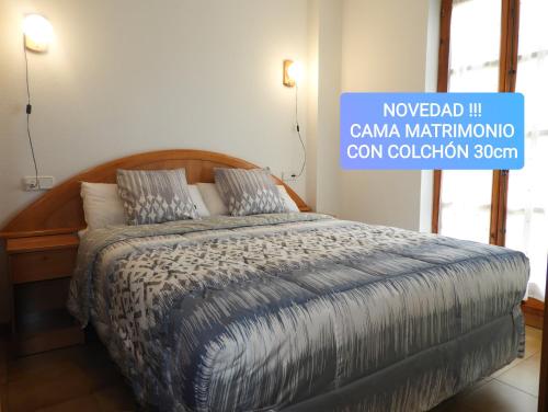 a bed in a bedroom with a sign that reads noored in canama nationality at UNIQUE EXPERIENCE - Boí-Taüll Apartment in Pla de l'Ermita