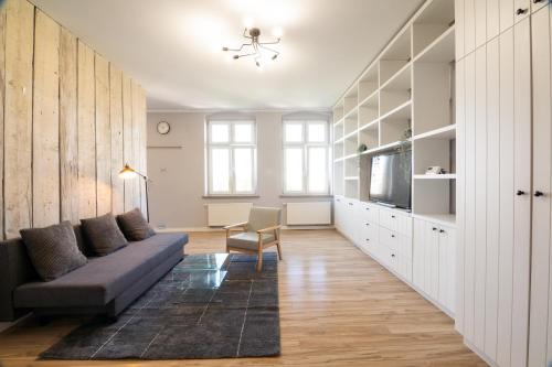 a living room with a couch and a tv at KING APART Gliniana 58 in Wrocław