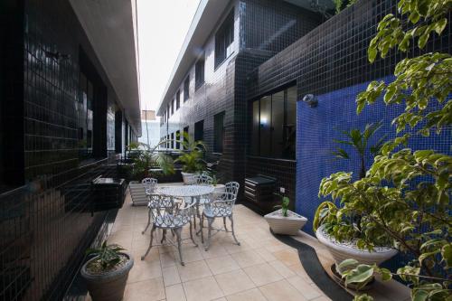an outdoor patio with tables and chairs and potted plants at Grande Hotel Guarapuava in Guarapuava