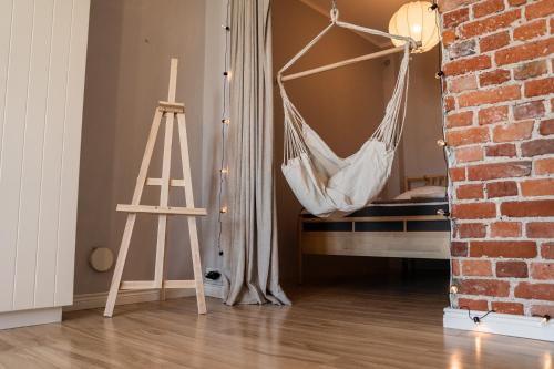 a hammock hanging in a room with a ladder at KING APART Gliniana 58 in Wrocław