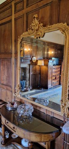 a mirror in a kitchen with a table in front of it at Braithwaite Hall Bed & Breakfast in Middleham