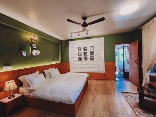a bedroom with a bed and a ceiling fan at Eco Farmstay Cottages #1 in Dharamshala