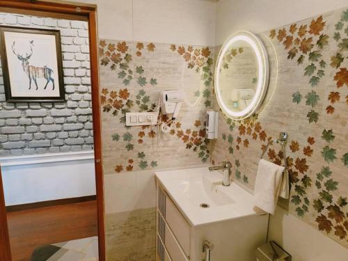 a bathroom with a sink and a mirror at Eco Farmstay Cottages #1 in Dharamshala