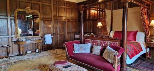 una camera con letto, divano e specchio di Braithwaite Hall Bed & Breakfast a Middleham