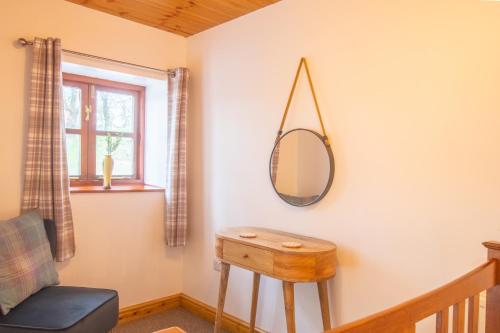 a dressing room with a mirror and a chair at Maes Madog Cottages in Betws-y-coed