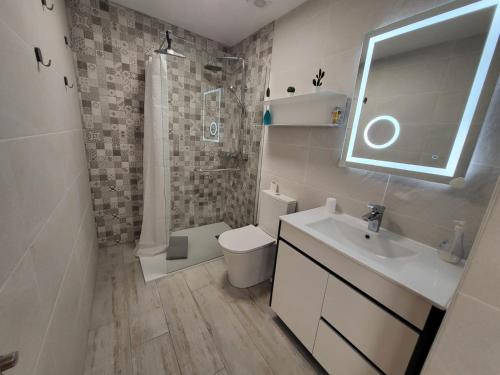 een badkamer met een wastafel, een toilet en een spiegel bij La Casa d'Olhão in Quelfes