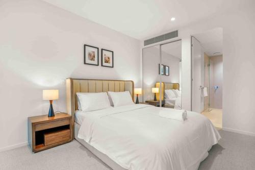 1 dormitorio con 1 cama blanca grande y mesita de noche en Glamorous 2BR Southbank home LV50! stunning view#MSQ5003, en Melbourne