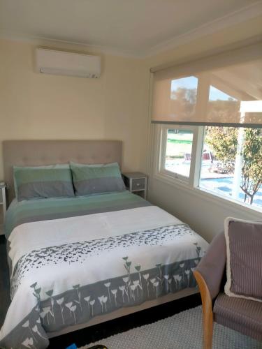 a bedroom with a bed and a window and a chair at Avonlea Cottages in York