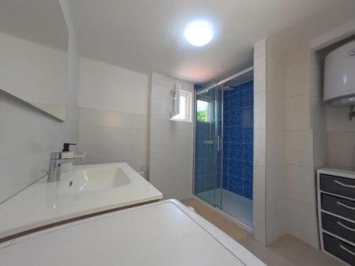 uma casa de banho branca com um lavatório e um chuveiro em Apartment Adria Lovran em Lovran