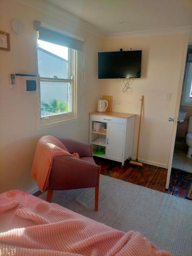 a living room with a couch and a television at Avonlea Cottages in York
