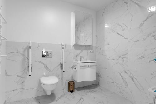 a white bathroom with a toilet and a sink at Klettar - The Old Hatchery Iceland in Fludir