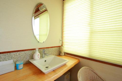a bathroom with a sink and a mirror at Family Ryokan Kawakyu with Showa Retro, private hot spring in Ibusuki