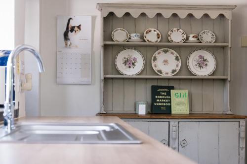 a kitchen counter with a sink and plates on a shelf at Wye Valley Holiday Cottage - Field Cottage in Peterstow