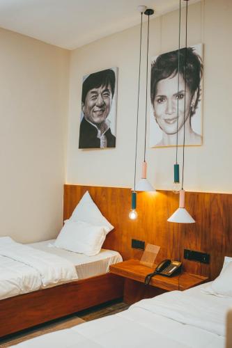 two beds in a room with posters on the wall at Burundi Palace Boutique Hotel in Bujumbura