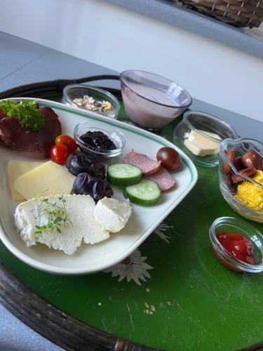 une assiette contenant différents types de denrées alimentaires sur une table dans l'établissement Rosenlund Gods - kælder B&B, à Sakskøbing