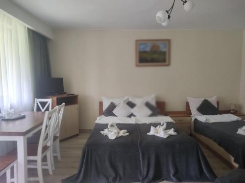 a bedroom with two beds and a table and a table and chairs at Zajazd u Kmity in Postołów
