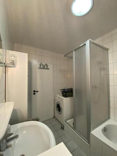 a bathroom with a sink and a washing machine at Ferienwohnung 24 Unten Rechts 3 Zimmer in Lathen