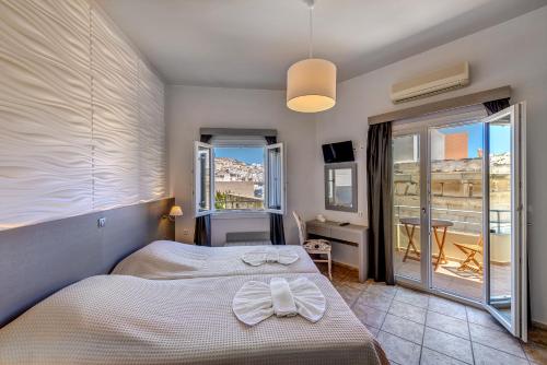a bedroom with a bed with a white bow on it at Ethrion in Ermoupoli