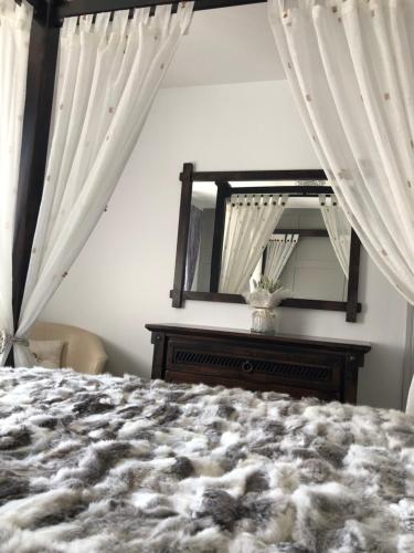 a bedroom with a bed and a mirror at Cleomack House - Perfect for two in Hilltown