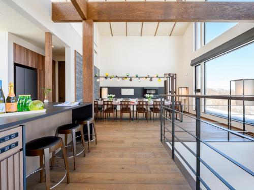 an open kitchen and dining room with a bar with stools at Panorama Niseko in Kutchan