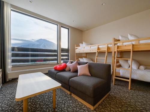 ニセコ町にあるPanorama Nisekoの二段ベッド2台とソファが備わる客室です。