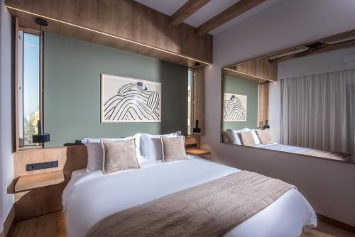 ein Schlafzimmer mit einem großen Bett und einem großen Spiegel in der Unterkunft Relaxo Collection Luxury Suites in the Heart of Heraklion in Iraklio