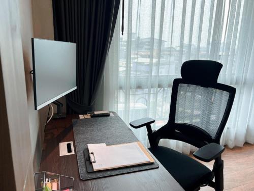 a room with a desk and a chair and a computer at Civilize Hotel in Udon Thani