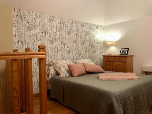 uma cama com duas almofadas num quarto em La Petite Maison Nature em Saint-Jacques-des-Blats