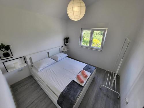 ein kleines Schlafzimmer mit einem Bett und einem Fenster in der Unterkunft Lana in Bibinje