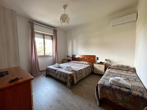 um quarto de hotel com duas camas e uma janela em hotel La pineta em Carrara