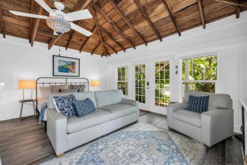 a living room with two couches and a ceiling fan at Cabin Style Pool Home w/ Guesthouse! Sleeps 10! in Stuart