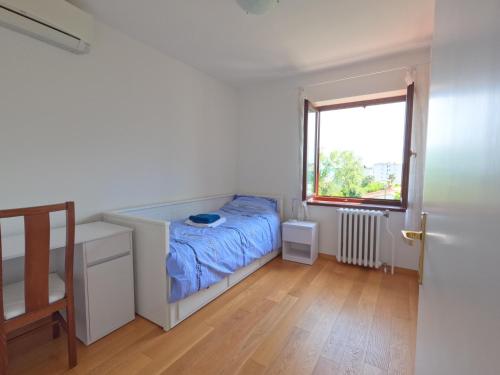 um pequeno quarto com uma cama e uma janela em Apartment Adria Lovran em Lovran